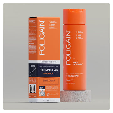 Erkekler için %2 TRIOXIDIL içeren FOLIGAIN üç etkili şampuan, turuncu şişe ve kutu.