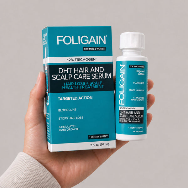 FOLIGAIN DHT saç ve saç derisi bakım serumu şişesini ve kutusunu tutan el, 60 mL.
